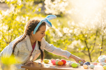 Teenage girl holding easter eggs in the backyard