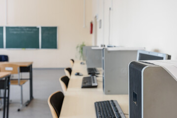 Empty modern classroom with chairs, desks, chalkboard and computers