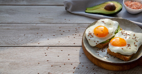 Avocado and egg toast on whole grain bread. Healthy food rich in healthy fats, proteins, antioxidants, fiber.