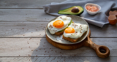 Avocado and egg toast on whole grain bread. Healthy food rich in healthy fats, proteins, antioxidants, fiber.