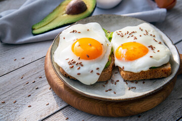 Avocado and egg toast on whole grain bread. Healthy food rich in healthy fats, proteins, antioxidants, fiber.