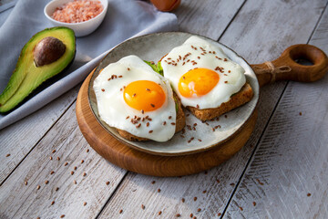 Avocado and egg toast on whole grain bread. Healthy food rich in healthy fats, proteins, antioxidants, fiber.