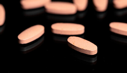 Obraz na płótnie Canvas Close up of Multi Vitamin tablet on a reflective black backgroun