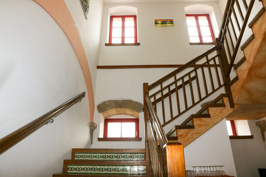 Treppenaufgang mit Geländer zur nächsten Etage mit Fenstern