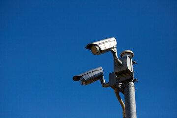 青空と電柱上の監視カメラの風景