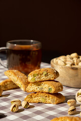 Biscotti Cantuccini Cookie Biscuits with pistachios and lemon peel Shortbread. Cup of tea. Teatime break Healthy eating food. Homemade fresh Italian cookies cantucci stacks and organic pistachios nuts