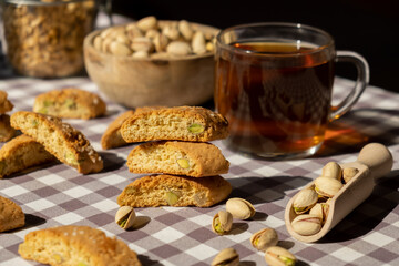 Biscotti Cantuccini Cookie Biscuits with pistachios and lemon peel Shortbread. Cup of tea. Teatime break Healthy eating food. Homemade fresh Italian cookies cantucci stacks and organic pistachios nuts