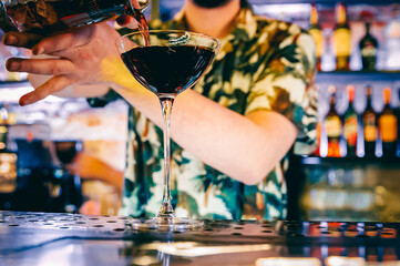man hand bartender making cocktail in glass on the bar counter