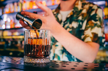 man hand bartender making cocktail in glass on the bar counter