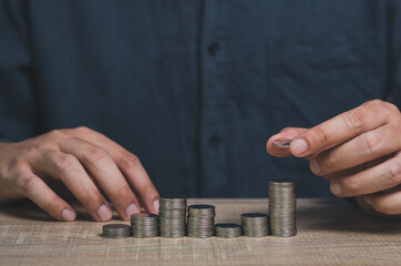 Businessman hand holding money on the desk. Saving money, income, earning and investment concept.