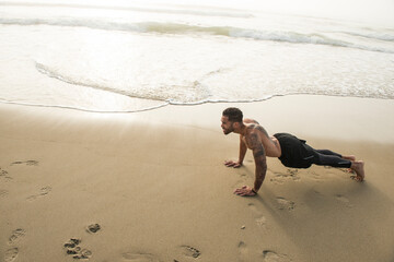 Muscular man exercising alone on sandy beach, Hampton, New Hampshire, USA