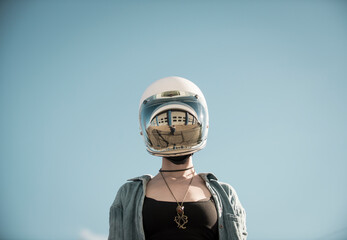 Centered perspective of a woman wearing a vintage motorcycle helmut with a reflection of a auto garage on the visor.