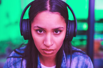 Headphones, portrait or gaming woman in neon home with focus, strategy or serious face expression...