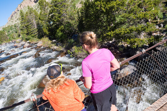 Mother and daughter on rope bridge over Popo Agie River, Sinks Canyon State Park, Lander, Wyoming, US