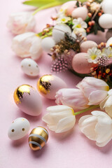 Easter golden eggs, gift box and decorations on pink  background.
