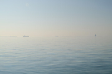 Ships on the horizon in the morning on the sea