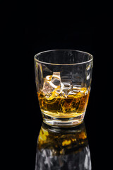 Whisky glass with ice on black background