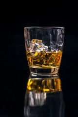 Whisky glass with ice on black background
