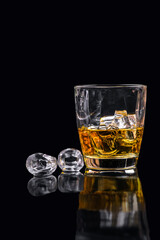 Whisky glass with ice on black background