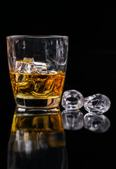 Whisky glass with ice on black background