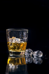 Whisky glass with ice on black background