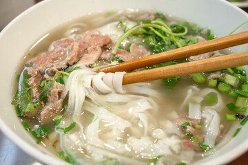Close up of a delicious pho noodle soup at a street restaurant in Hanoi Vietnam.