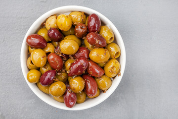 Mixed marinated olives on grey surface with copy space