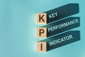 There is wood cubes with the word KPI. It's an abbreviation for Key Performance Indicator.