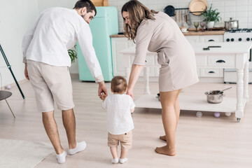 Happy parents with little son on modern kitchen, family enjoying weekend at home together