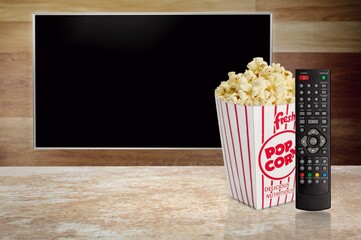 TV with a tasty popcorn and a modern remote control.