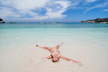 Vacation on the seashore. Young woman relaxing on the beautiful tropical white sand beach.