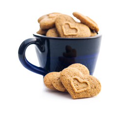 Sweet gingerbread hearts in cup isolated on white background.