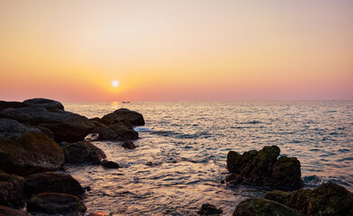 Fototapeta na wymiar Beautiful landscape with sunset on the sea rock beach.