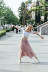 a woman in a pink skirt dancing in the street