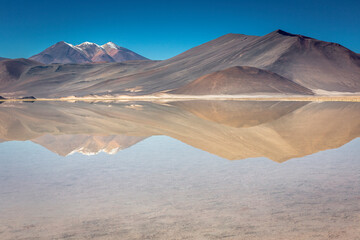 Fototapeta na wymiar Salt lake in Piedras Rojas, volcanic landscape at sunrise, Atacama, Chile