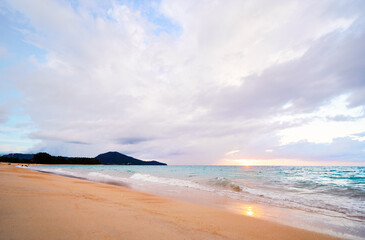 Seascape with sunset on the ocean shore. Beautiful cloudy sky.