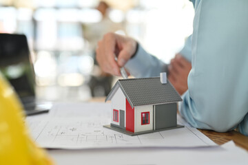 Model of houses with blueprint on white table. Real estate, building, construction, architecture, and property concept