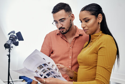 Documents, teamwork or planning with a photographer and model talking in a studio for creative production. Collaboration, designer or fashion with a designer man and woman at work on a magazine shoot