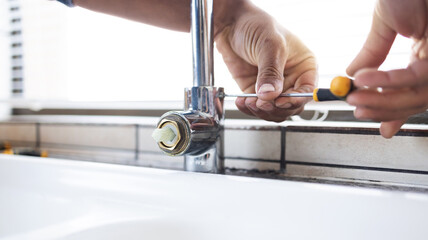 Obraz premium Plumber man, tap and hands with screw tools of building maintenance, renovation and service. Closeup handyman, faucet and plumbing of engineering contractor, upgrade pipeline system and mechanic work