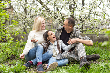 Fototapeta premium Handsome soldier reunited with family on a sunny day.