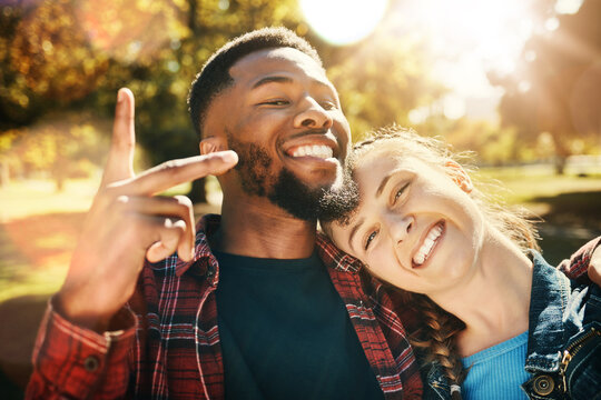 Couple smile, selfie peace sign and portrait outdoors, enjoying fun time and bonding at park. Interracial, love romance and black man and woman with v hand emoji for taking pictures for happy memory.