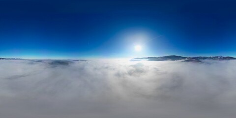 360 panorama aerial drone view above the sea of clouds and surrounded by mountains with a deep blue sky and a beautiful radiant sun, a fairy tale-like dreamy cotton bed at altitude