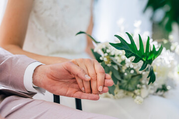 Braut und Bräutigam halten einander die Hände