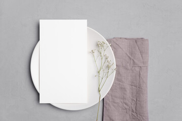 Wedding paper blank menu card mockup on white plate with flowers, copy space