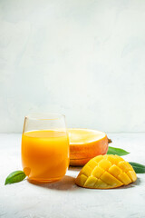 Tasty mango drink and fresh fruits on a light background. vertical image. top view. place for text