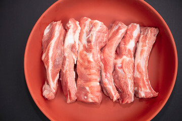 raw pork ribs for cooking on a dark background