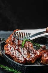 Grilled pork steak in frying pan on a dark background. American food concept. banner, menu, recipe place for text, top view