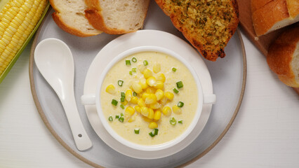 Corn Soup and Bread breakfast menu on white table