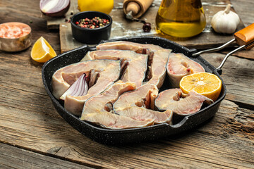 raw fillet steak of sturgeon fish on a grill pan on a wooden background,
