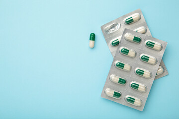 Medical blister packs with pills on blue background. Space for text